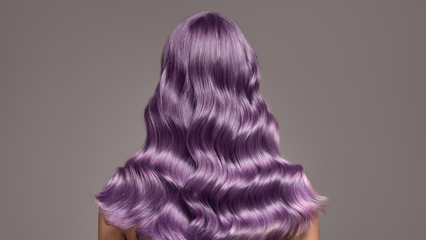 hairdressers specialising in curly hair in Lewisham and London long curly purple hair model against grey background
