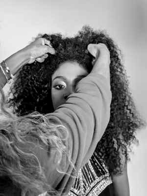 hairdressers specialising in curly hair in Lewisham and London model having her curls adjusted for photo in black and white